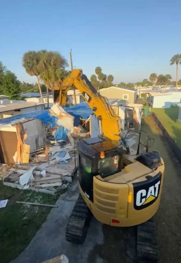 Mobile home being torn down by excavator